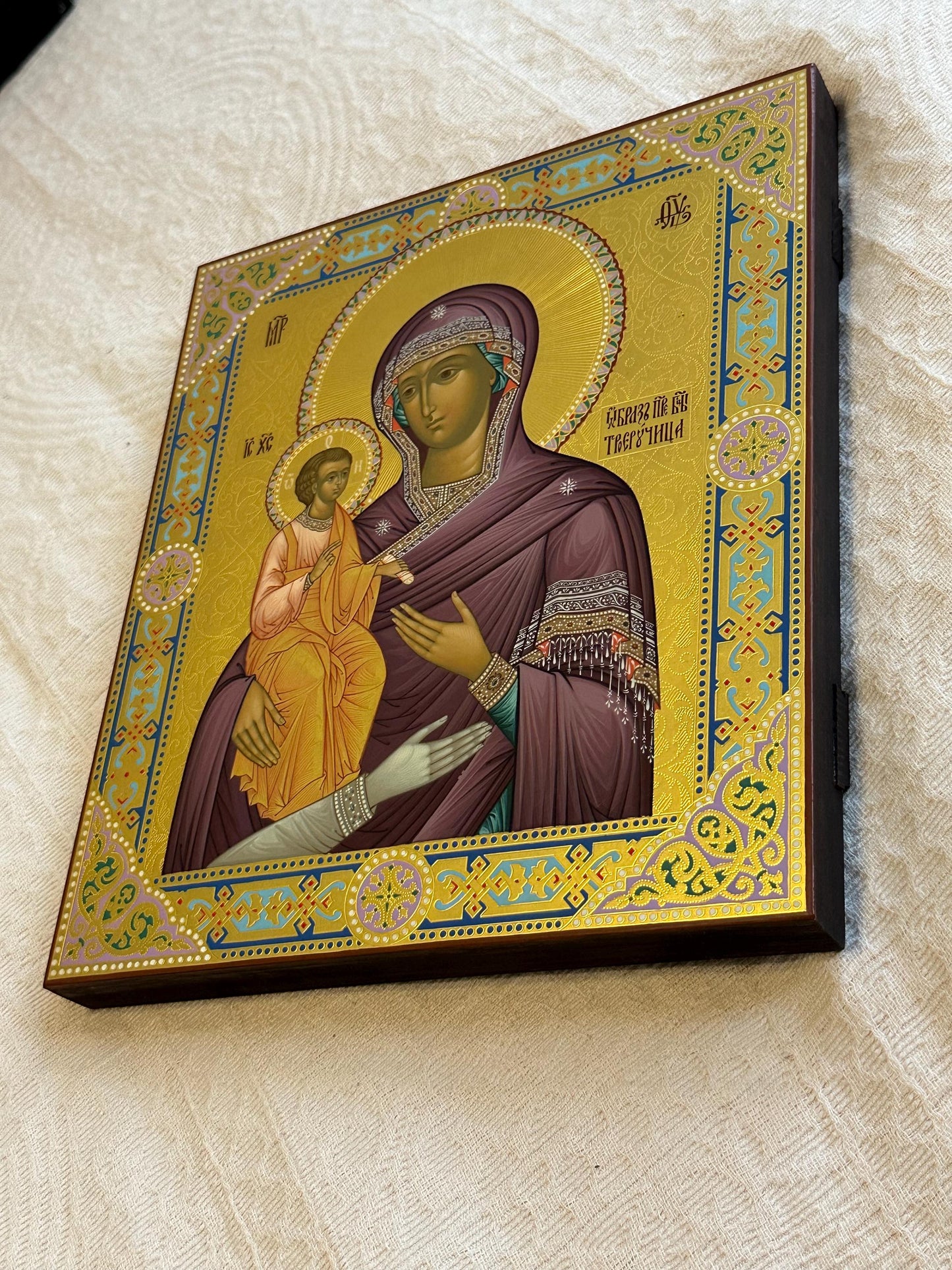 Hand painted icon of Mother of God on wooden board covered with gold leafs